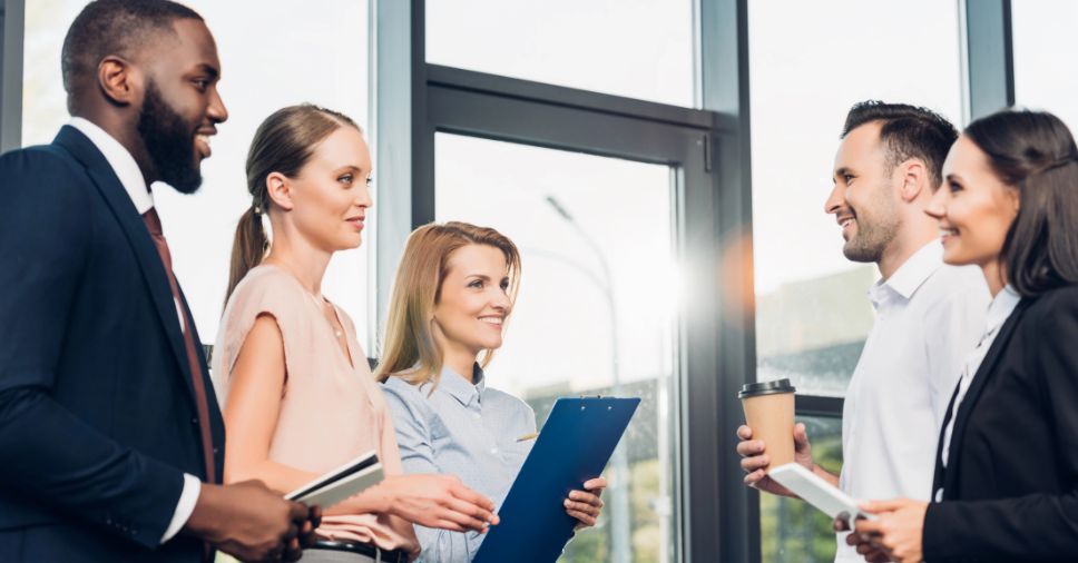 Colaboradores interagem felizes, reflexo de copa corporativa bem gerenciada