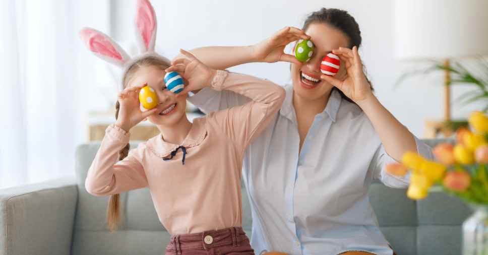 Criança e mulher se divertindo em festa de Páscoa corporativa.